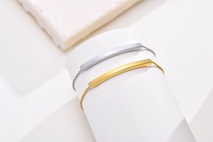 Macro detail of polished gold and silver curved bar bracelets on a white display