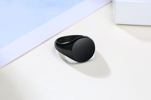 Minimalist black stainless steel signet ring with a smooth round flat surface and modern style