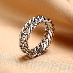 Vue macro d'une bague gourmette argentée sur un tissu en soie de couleur champagne