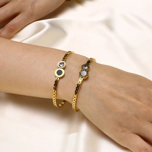 Détail du bracelet doré avec chiffres romains, zircon et nacre sur tissu de soie
