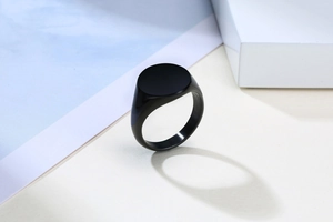 Minimalist black stainless steel signet ring with a smooth matte circular top surface