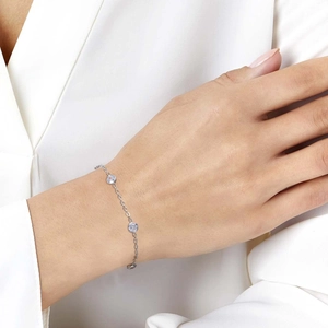 Detail of silver station bracelet with bezel-set round white zircons on a woman's wrist