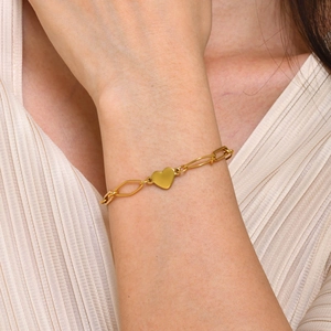 Nahaufnahme eines minimalistischen goldenen Herzarmbands aus Edelstahl am Handgelenk