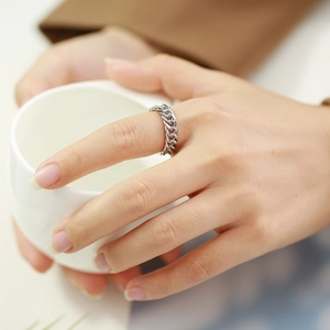 Détail de la bague chaîne cubaine en acier inoxydable poli sur le doigt d'une femme