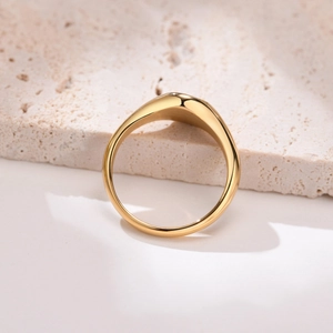 Dettaglio dell'anello in acciaio inossidabile dorato lucido su pietra di travertino