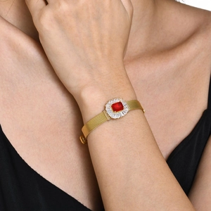 Vue détaillée d'un bracelet maille dorée avec une pierre rouge rectangulaire et des cristaux