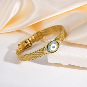 Détail d'un bracelet en maille dorée avec charme œil maléfique et pierres étincelantes