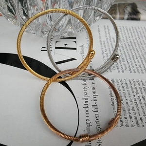 Set of gold and silver twisted wire cable open bangles on a stylish fashion magazine