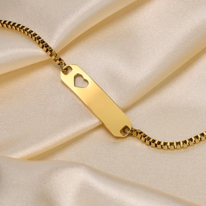 Detail of gold stainless steel bar bracelet with hollow heart and box chain on silk