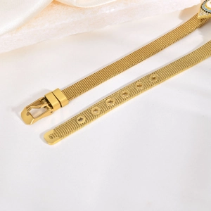 Détail macro du bracelet à mailles dorées avec pendentif œil protecteur serti de cristaux