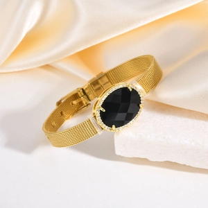 Détail du bracelet doré en maille avec gemme noire ovale et entourage de cristaux brillants
