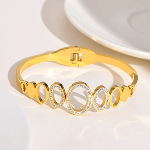 Détail d'un bracelet doré à maillons ovales ajourés sertis de zircons cubiques brillants