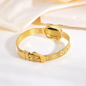 Détail du bracelet en maille dorée réglable avec fermoir boucle sur fond de pierre