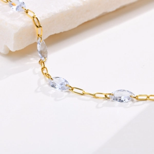 Macro shot of gold marquise-cut zircon stones on a fine stainless steel chain