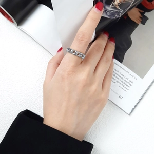Gros plan d'une bague à maillons argentée portée à l'index pour un style moderne