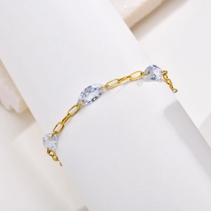 Detailed shot of golden thin chain bracelet featuring three marquise-cut clear stones
