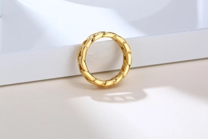 Détail d'une bague chaîne torsadée dorée avec finition hautement polie et design épuré