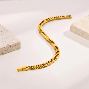 Gros plan sur le bracelet à maillons cubains en acier doré avec fermoir robuste et chic