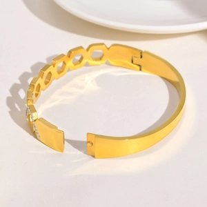 Détail d'un bracelet doré avec chiffres romains, zircons blancs et maillons géométriques