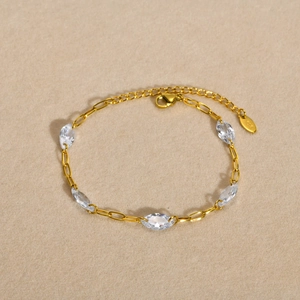 Golden stainless steel bracelet featuring five marquise cut white zircons on a cross chain