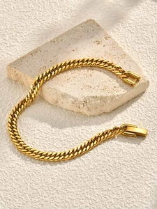Détail d'un bracelet gourmette doré avec fermoir pliant carré sur support en pierre