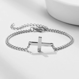 Detailed shot of polished silver stainless steel cross bracelet with adjustable lobster clasp