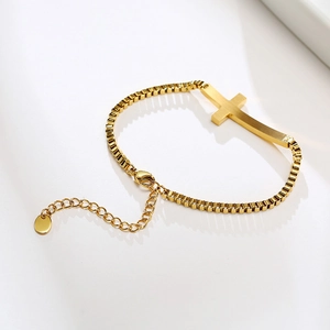 Close-up of gold-plated stainless steel box chain bracelet with cross pendant and clasp
