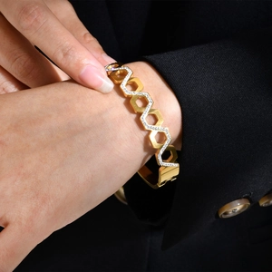 Gros plan d'un bracelet alvéolé doré serti de zircons sur le poignet d'un modèle