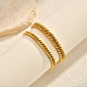 Bracelets gourmettes dorés polis pour femmes présentés sur un support cylindrique blanc