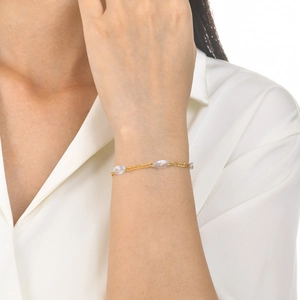 Detail of gold titanium steel bracelet featuring marquise-cut white zircon on a flat chain