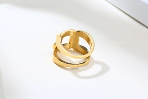 Détail macro d'une bague double dorée au design géométrique avec texture brossée