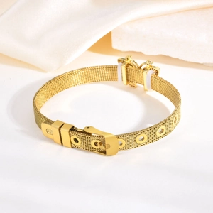 Détail du bracelet en maille d'acier doré avec breloque nœud et sangle de montre réglable