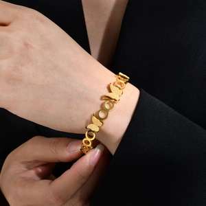 Détail d'un bracelet papillon doré avec finition mate et anneaux polis brillants