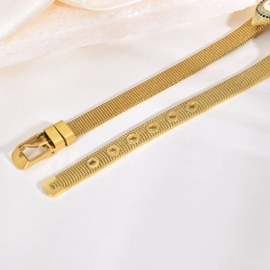 Détail du bracelet en maille d'acier doré avec breloque œil bleu et boucle de réglage