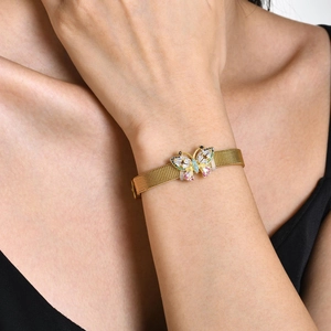 Détail d'un bracelet papillon doré avec pierres colorées sur un poignet de femme