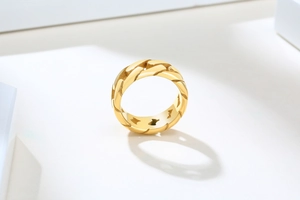 Vue détaillée de la texture maille gourmette dorée polie sur la bague en acier