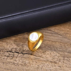 Detailed close-up of golden stainless steel ring featuring a white shell inlay disk