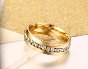 Macro detail of gold titanium ring band with pavé set white crystals on a glitter backdrop