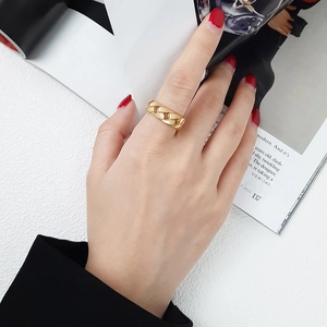 Détail d'une bague chaîne à maillons cubains dorée portée au doigt pour un style mode