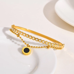 Détail macro du bracelet plaqué or avec chiffres romains et zircons étincelants