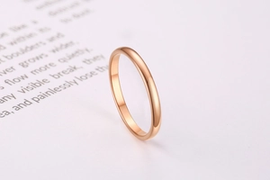 Macro shot of polished rose gold stainless steel minimalist band on book page