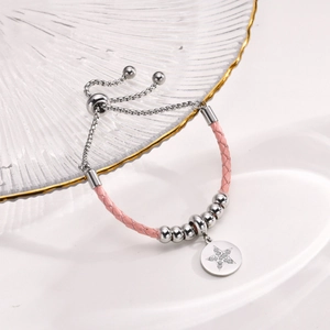 Macro shot of pink braided leather bracelet with adjustable slide clasp and star charm