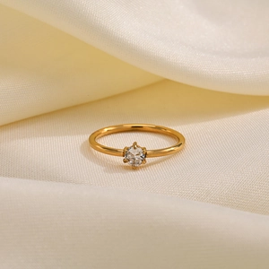 Close-up of elegant gold ring featuring a sparkling round-cut cubic zirconia in six-prong setting