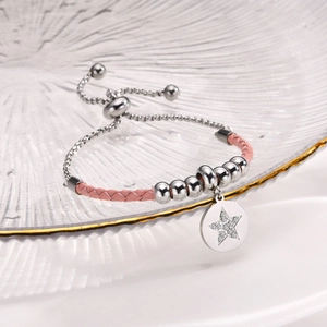 Macro detail of pink leather bracelet with silver star charm and adjustable bead