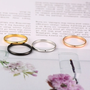 Detailed display of four minimalist stainless steel rings in gold, silver, black, and rose gold