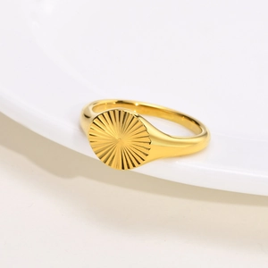 Minimalist gold oval signet ring featuring sunburst pattern engraving on polished surface
