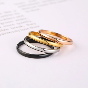 Macro view of four polished stainless steel rings in black, silver, gold, and rose gold