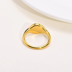 Macro detail of high-polish gold oval signet ring with flat top and wide band