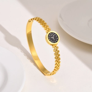 Gros plan de la montre bracelet dorée avec cadran noir LOVE et détails en zircon poli