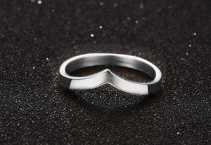 Detailed view of polished silver-colored V-shape titanium steel ring on textured background